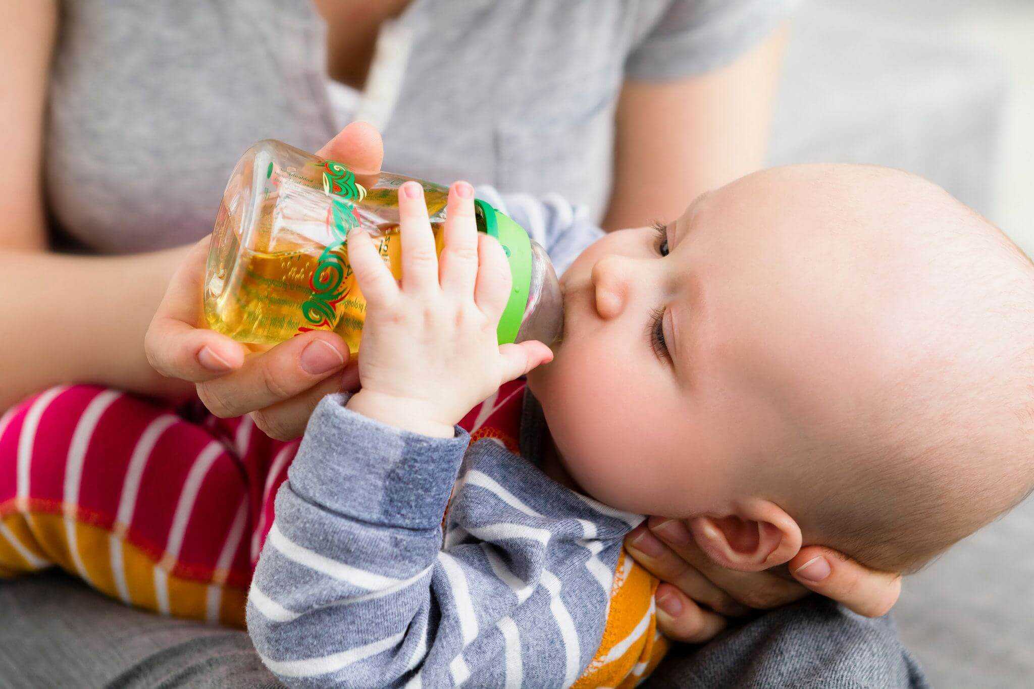 Соки дают ребенку грудного возраста. Малыш пьет сок. Малыш пьет бутылочка. Сок для детей. Малыши пьют яблочный сок.